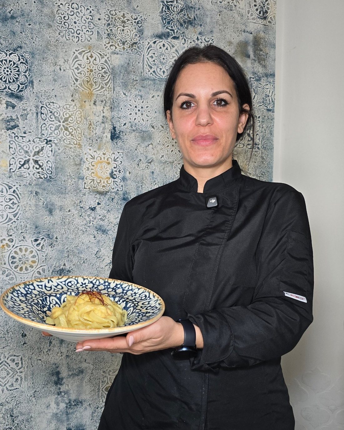 La chef Francesca Sorrentino con un piatto di pasta nella sala delle maioliche